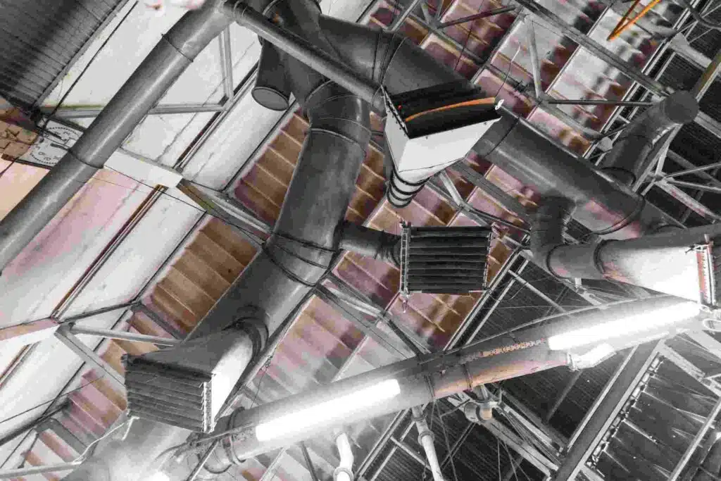 Industrial HVAC ductwork and ventilation systems in a glass manufacturing facility.